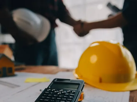 To byggeledere drøfter et projekt på en byggeplads.